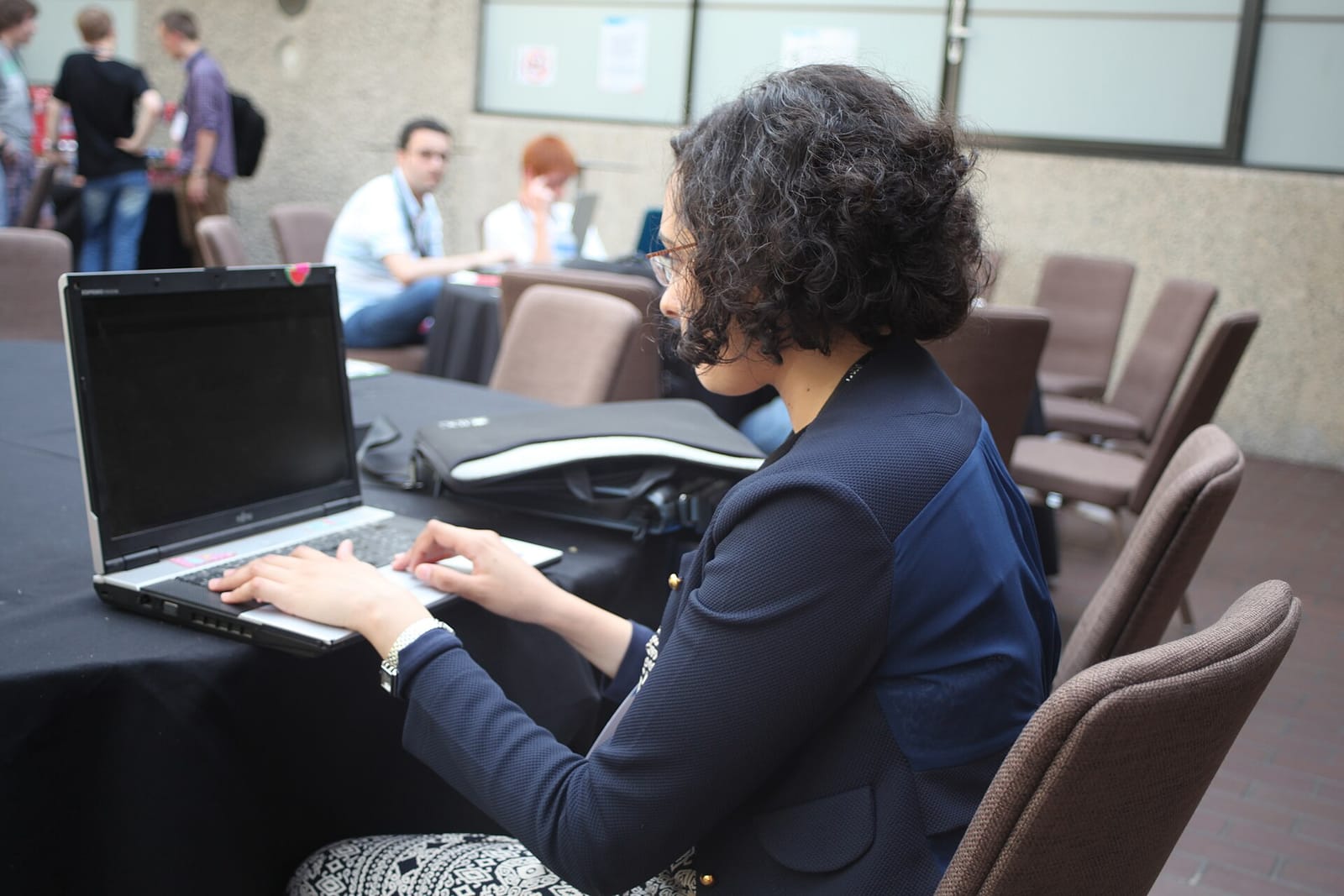 Participants working on laptops at a community hackathon