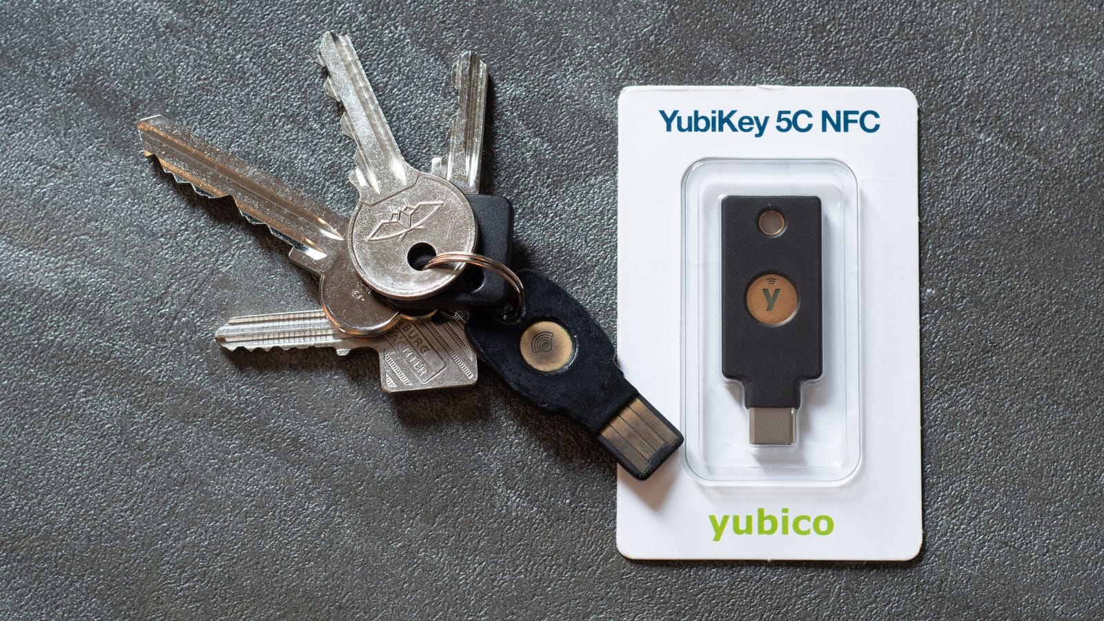 A YubiKey hardware security key on a keyring next to one in its retail packaging