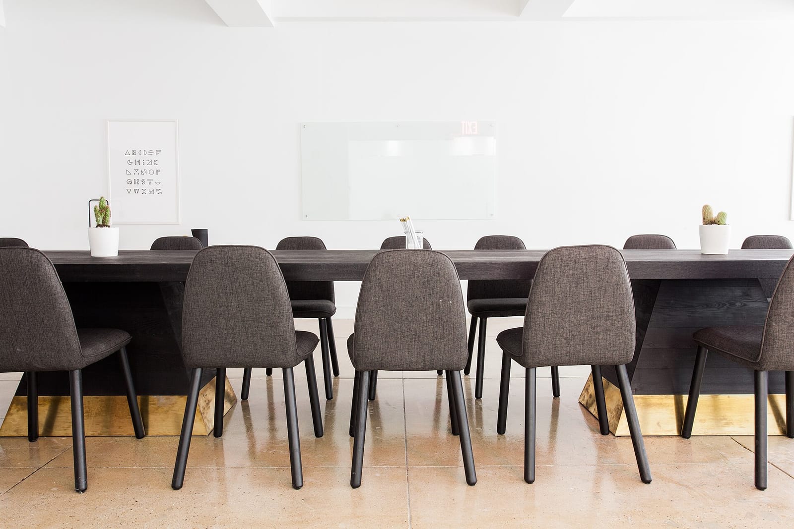 An empty corporate meeting room with a long table and grey chairs