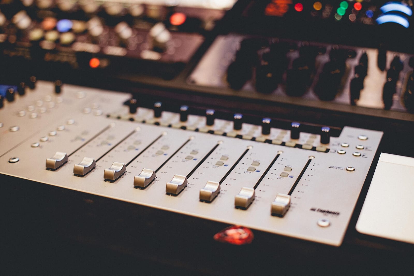 Close-up of faders on an audio mixing console in a studio