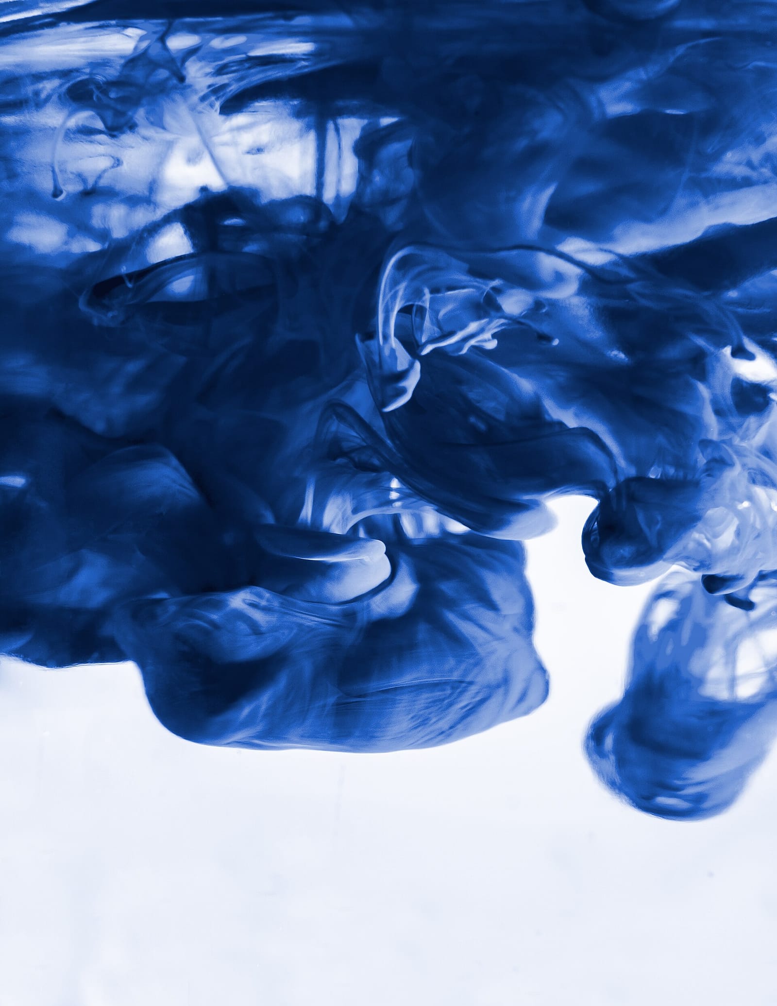 Blue ink spreading and diffusing through water