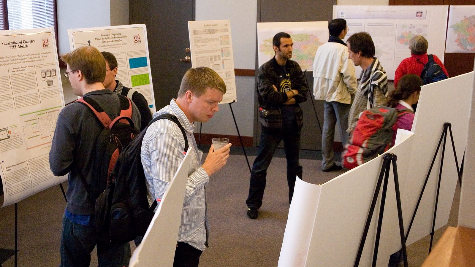 Attendees talking with presenters at a poster session of an academic computer science conference