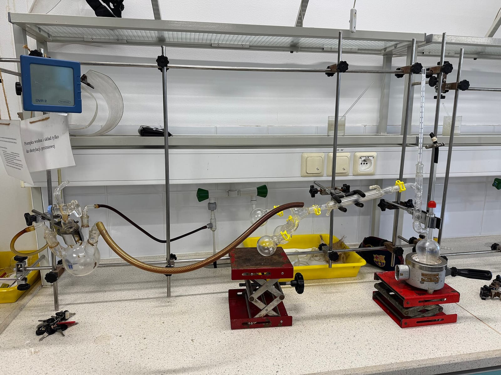 Laboratory distillation glassware clamped to a frame on a lab bench