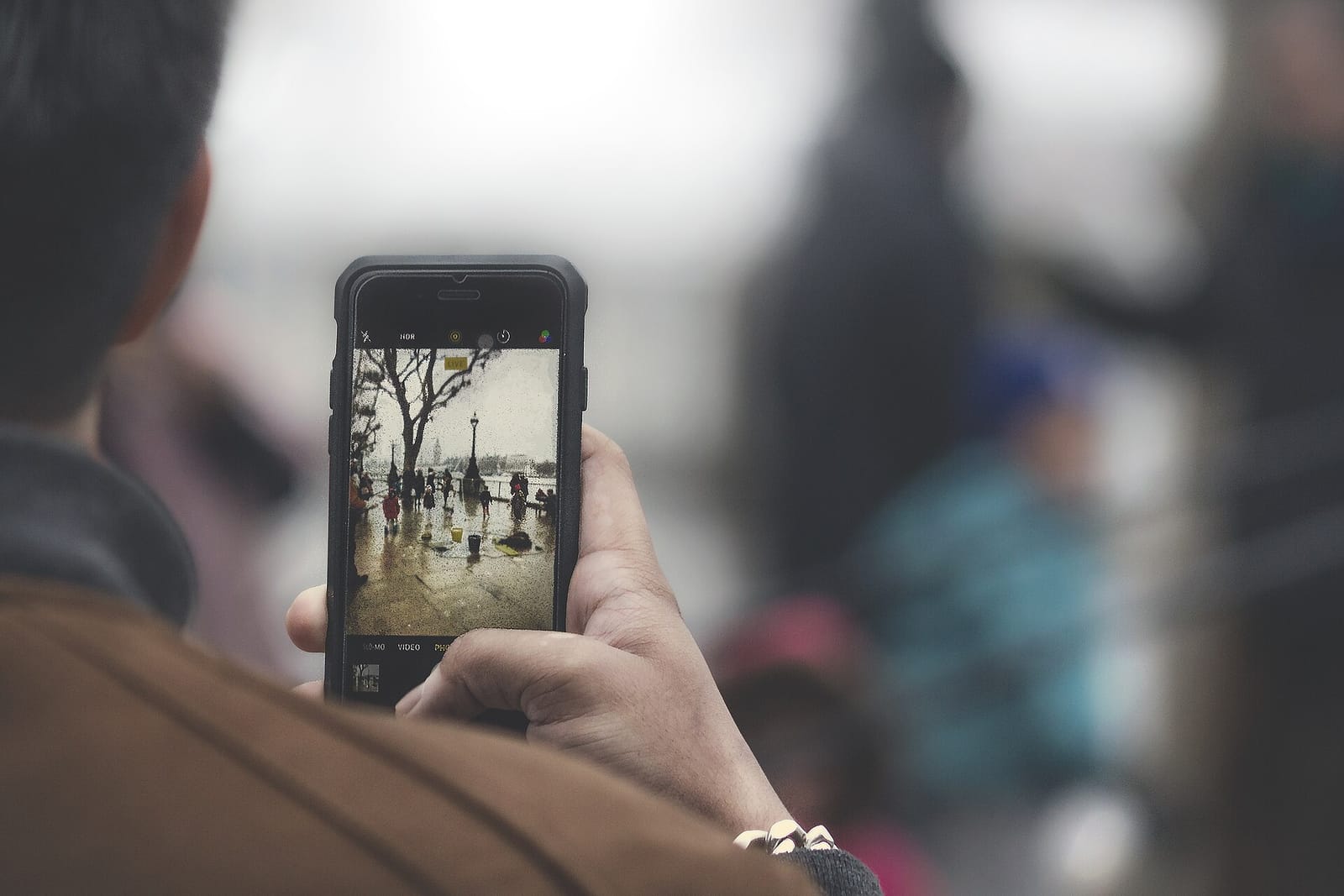A person taking a photo with a smartphone held up in their hand
