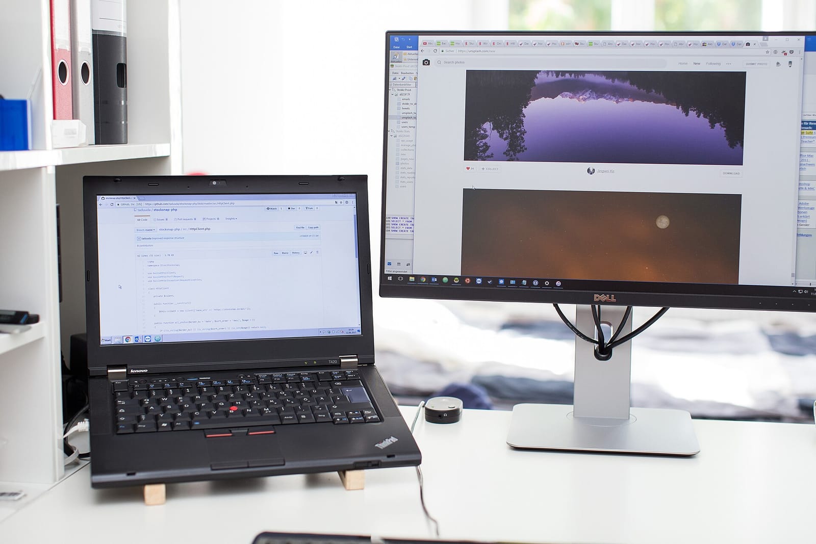 Laptop and external monitor on a desk showing data plots and code