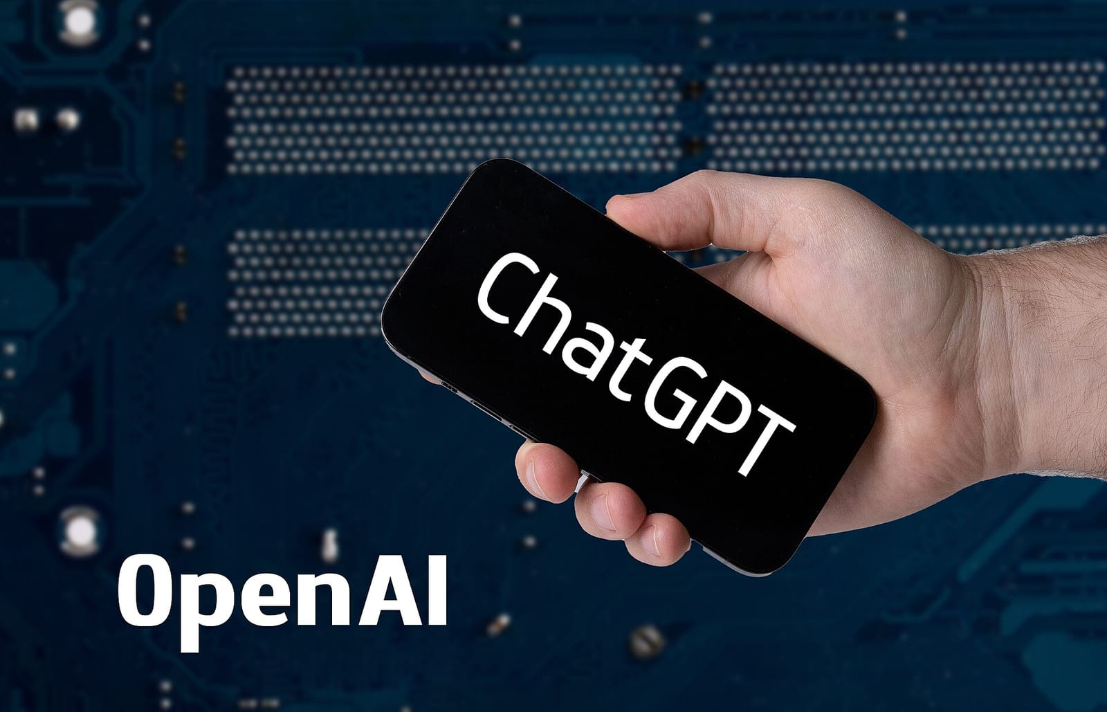 Hand holding a smartphone showing ChatGPT and OpenAI text