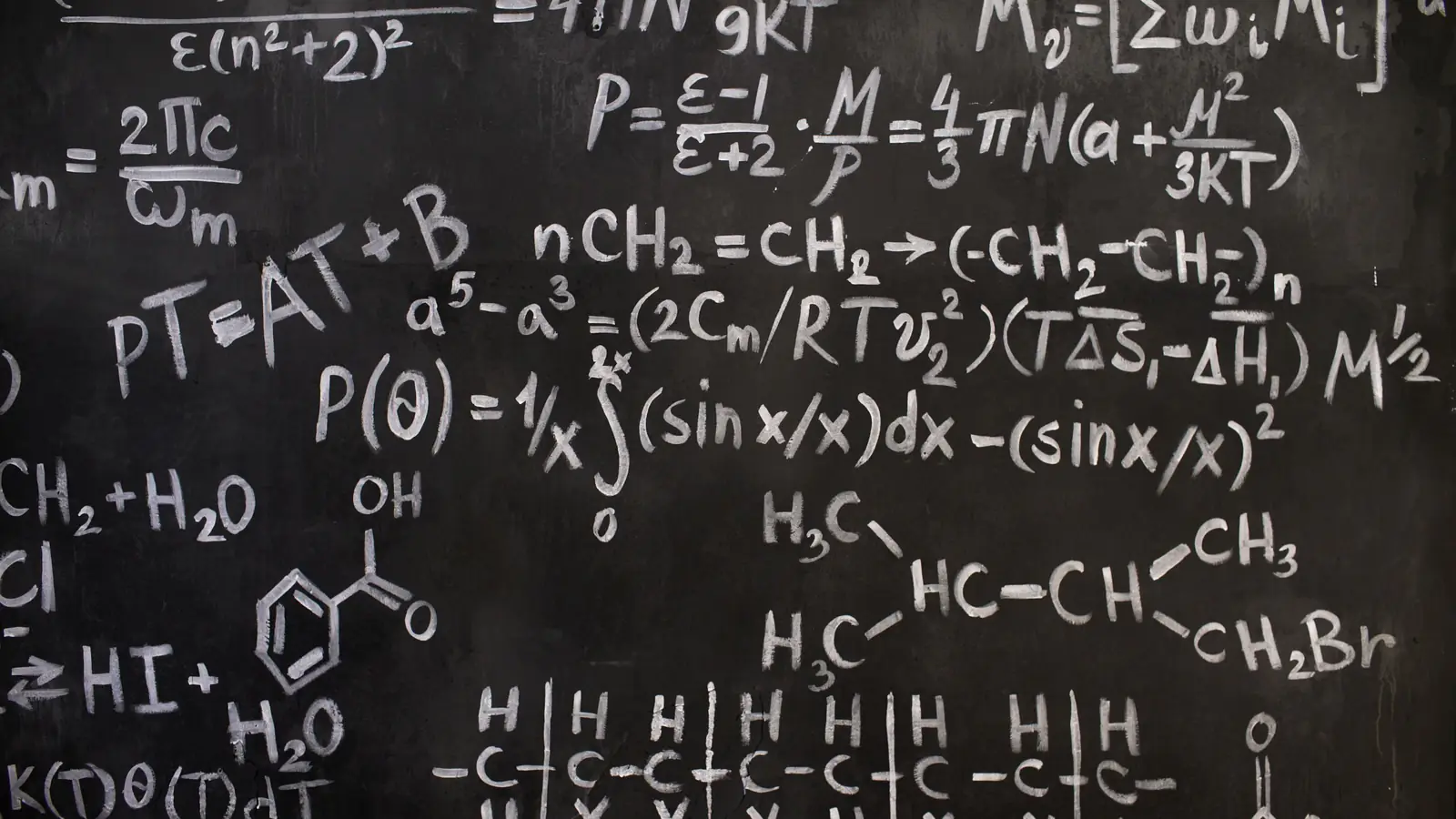 Close-up of dense mathematical formulas written on a blackboard