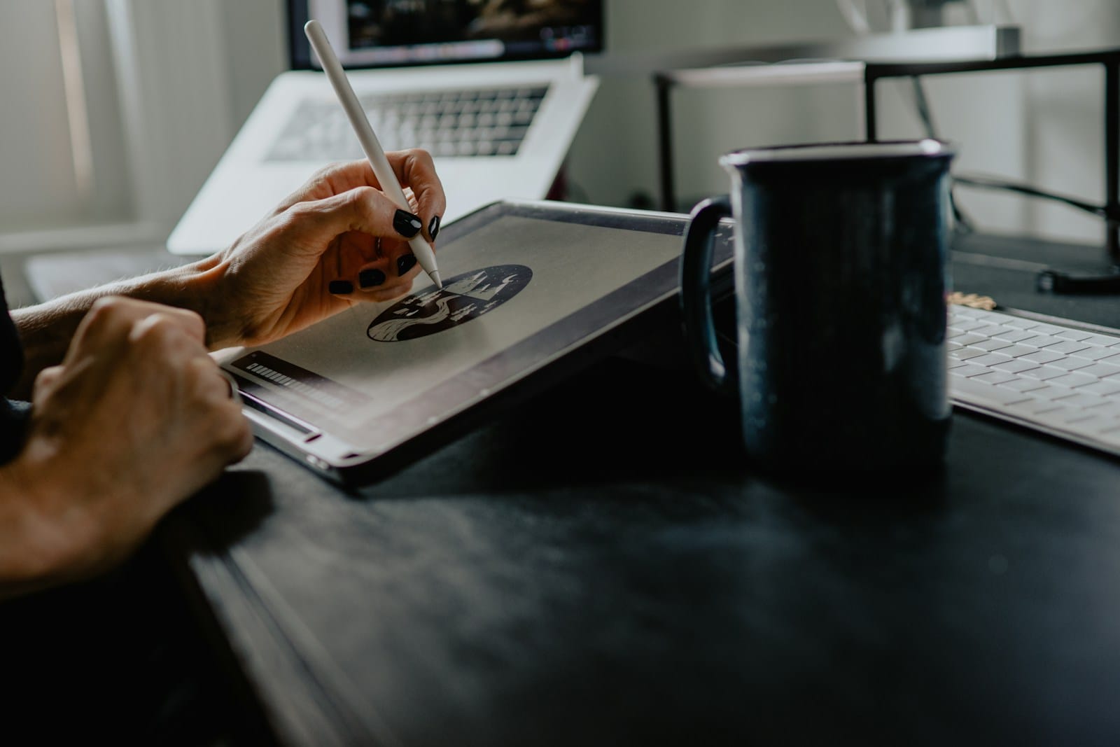 Person drawing on a tablet with a stylus at a desk