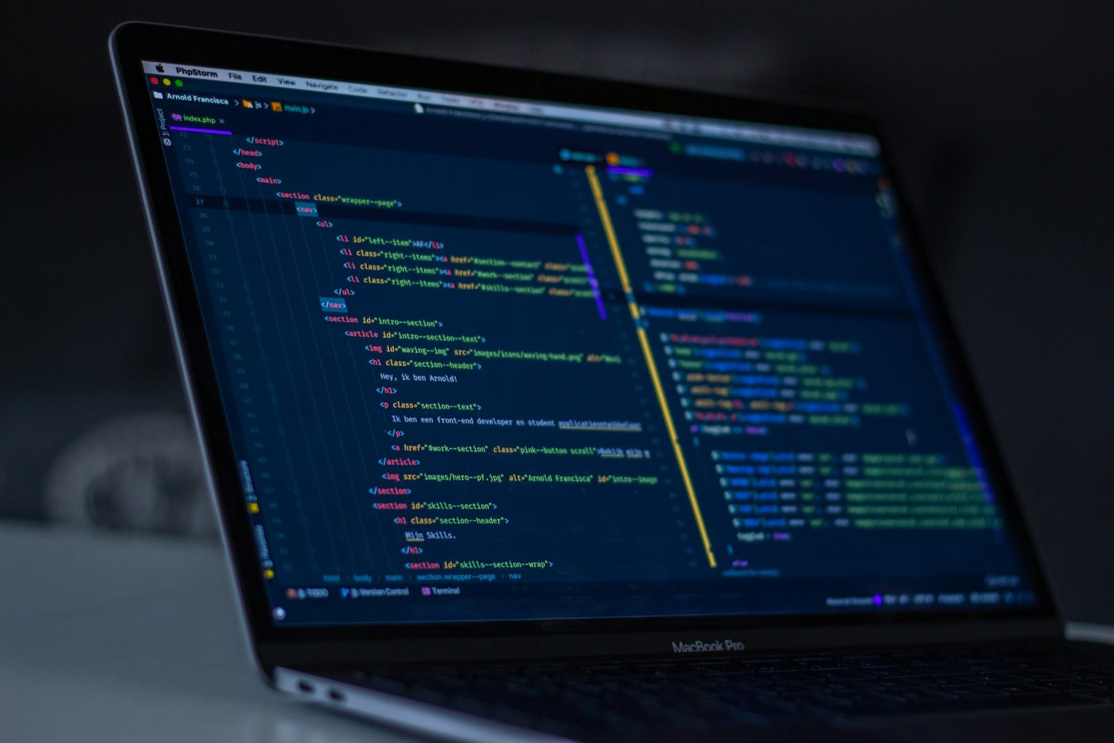 MacBook Pro showing programming code on a dark editor